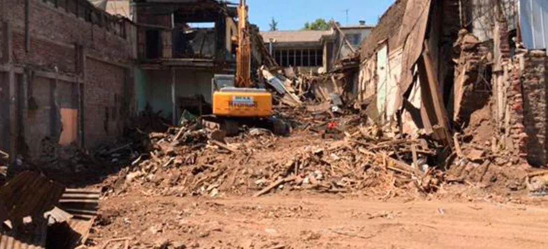 Excavadora entre los escombros de una instalación industrial demolida